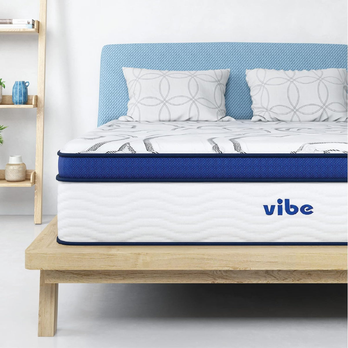 White gel-foam mattress with blue trim close-up on a light wood platform bed, front view