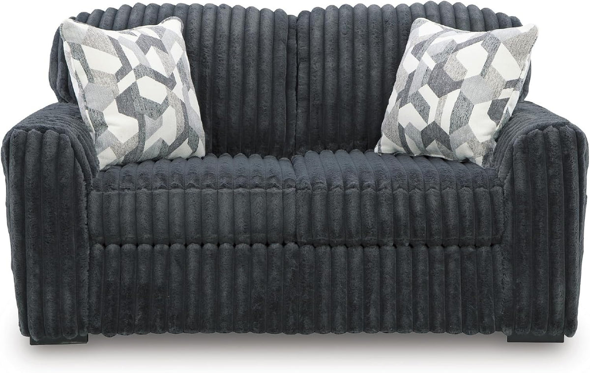 Front-facing charcoal gray corduroy loveseat with two geometric patterned throw pillows
