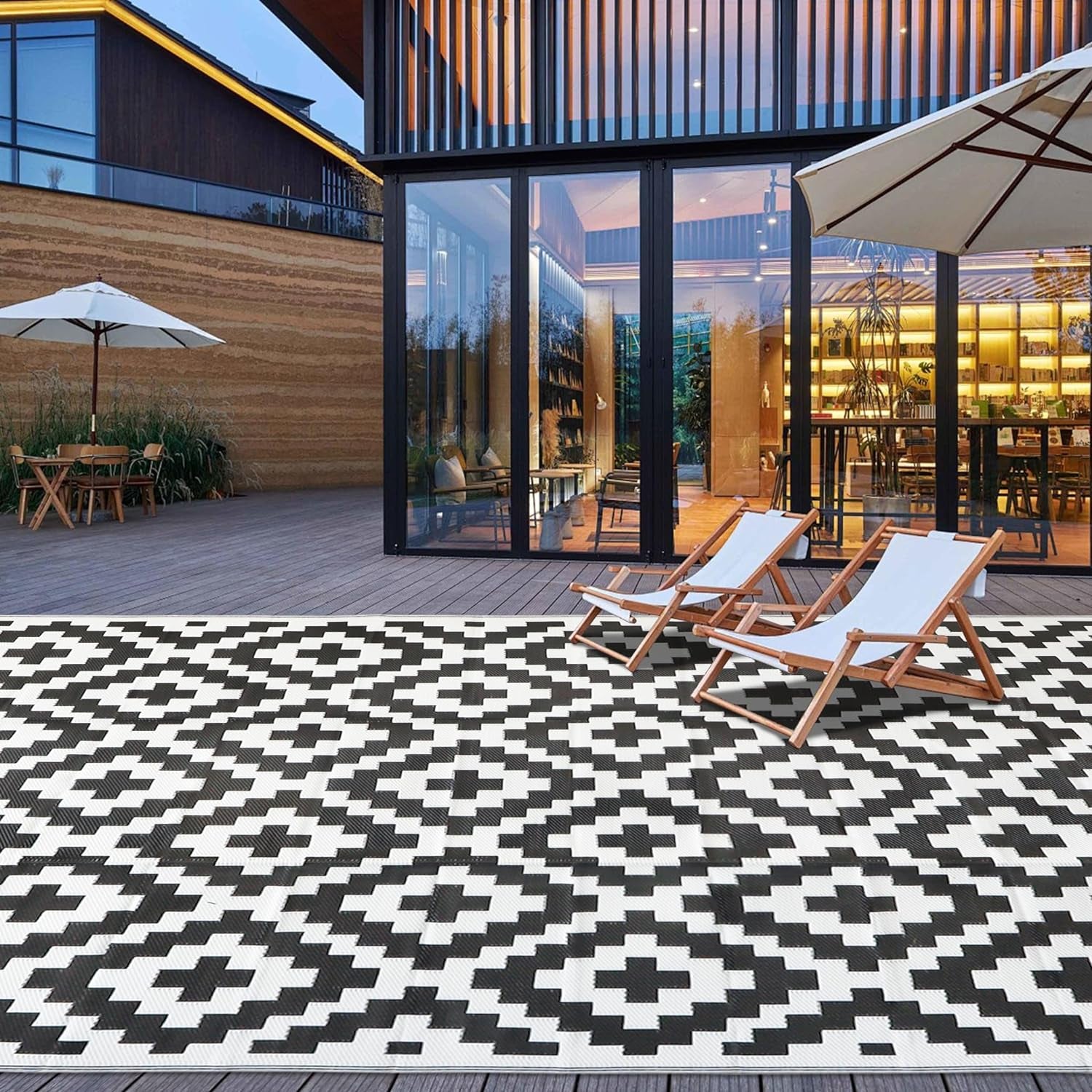 Deck area with two lounge chairs placed on a large white-and-black patterned outdoor rug
