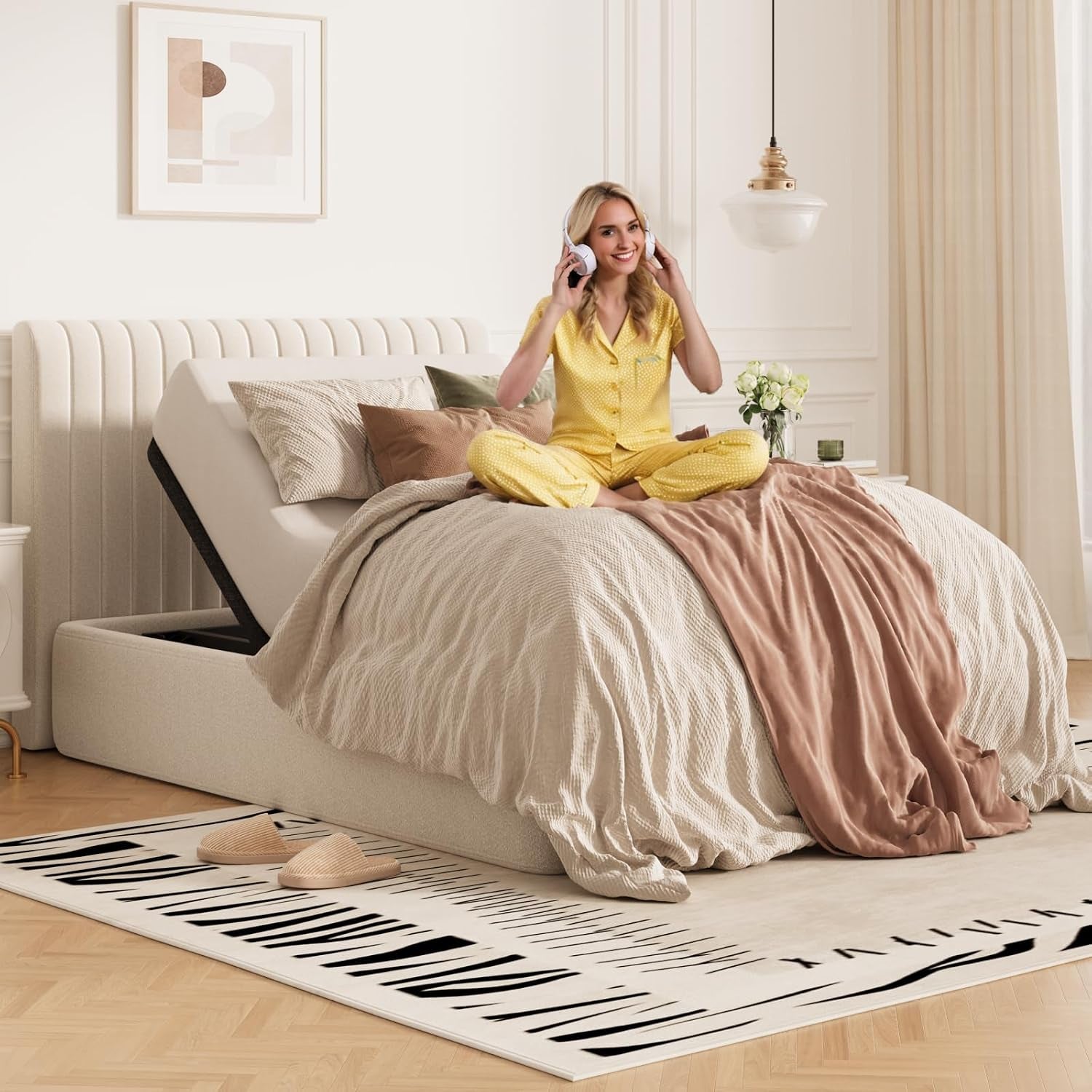 Adjustable bed base with head raised and woman in yellow pajamas seated on the bed