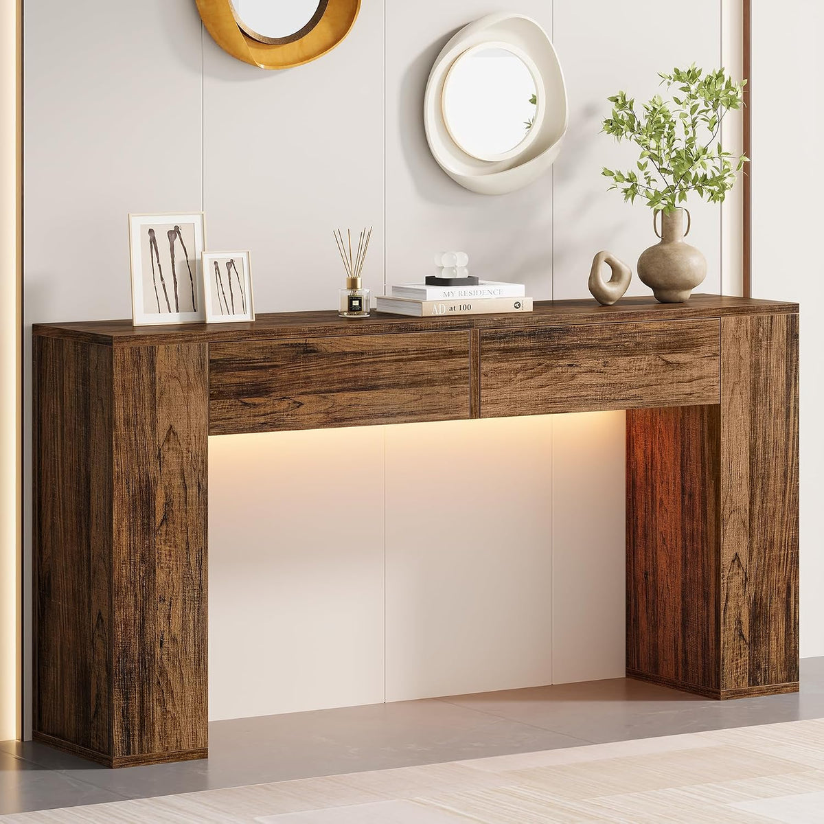 Dark wood-finish console table with round mirrors above and decorative books and vase on the top.