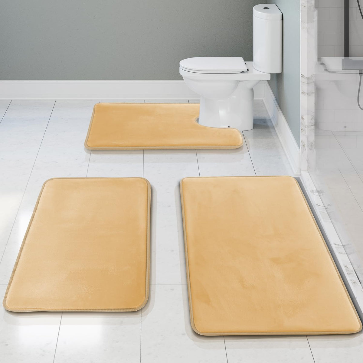 Overhead view showing two rectangular mats and a U-shaped contour mat in pale gold on tiled floor.