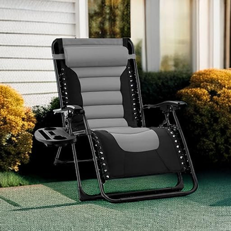 Black and gray padded recliner set on a green outdoor patio