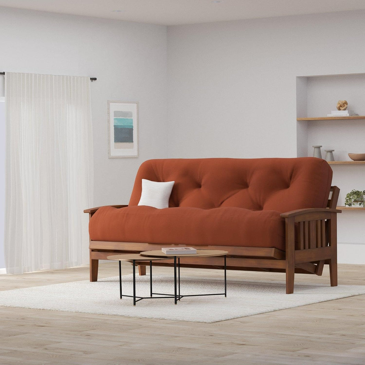 Full-size futon with rust cushion on curved-armed wood frame styled in a bright living room