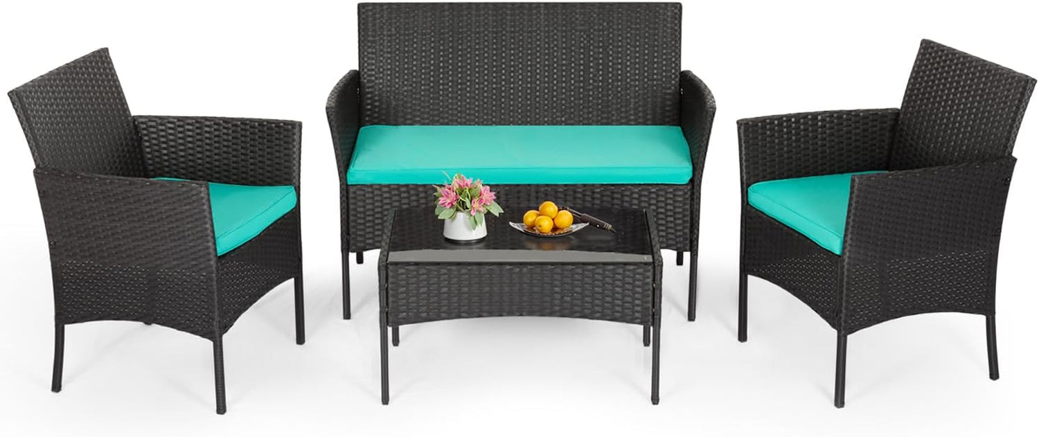 Four-piece dark rattan patio set with turquoise seat cushions and glass-top coffee table on white background