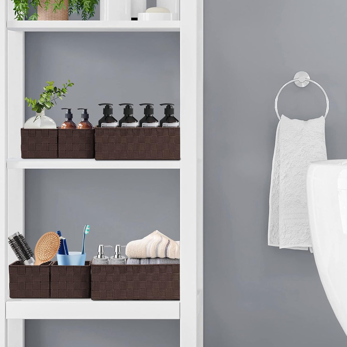 Brown woven baskets arranged on a white bathroom shelf holding toiletries, side view