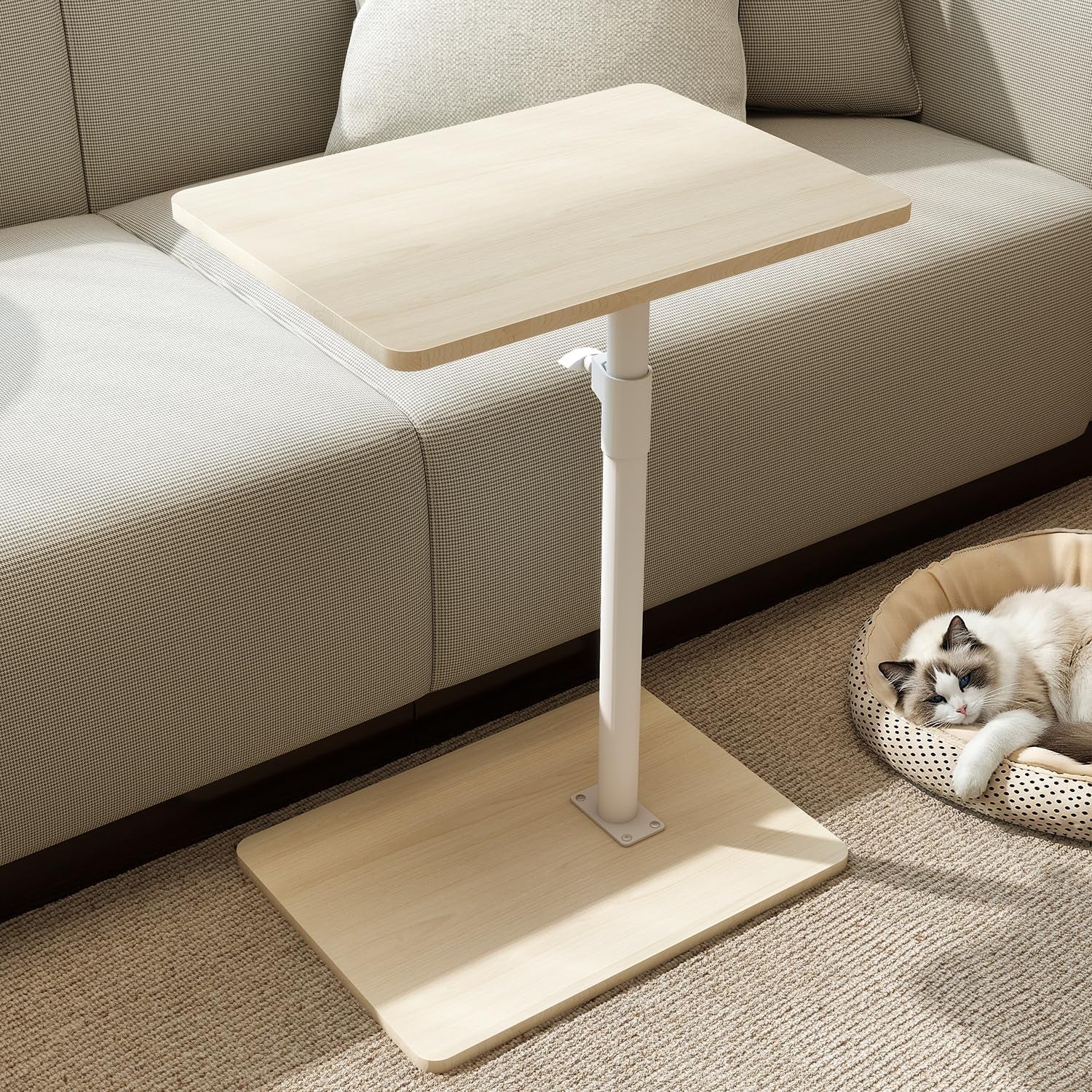 C-shaped light wood side table with white pole beside a beige sofa and cat bed on carpet