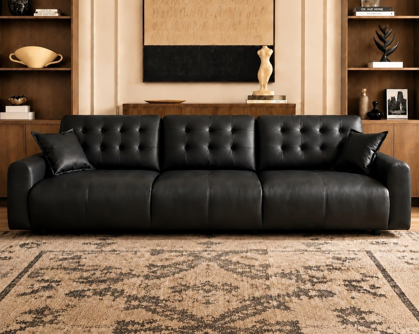 Front-facing close view of a tufted leather sofa centered on a patterned rug beneath wall art.