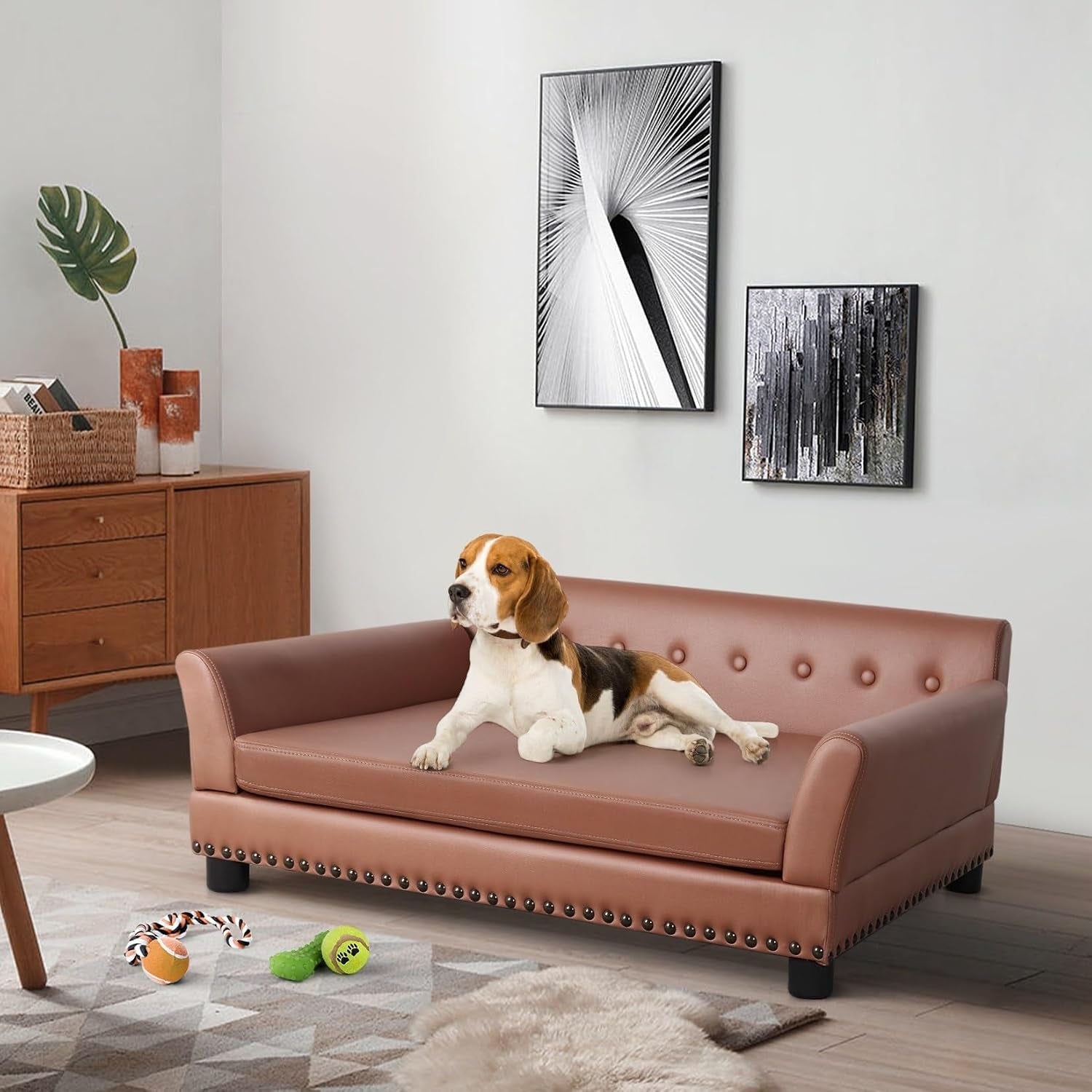 Brown leather dog sofa placed in a living room with a beagle lounging on it and toys on the floor