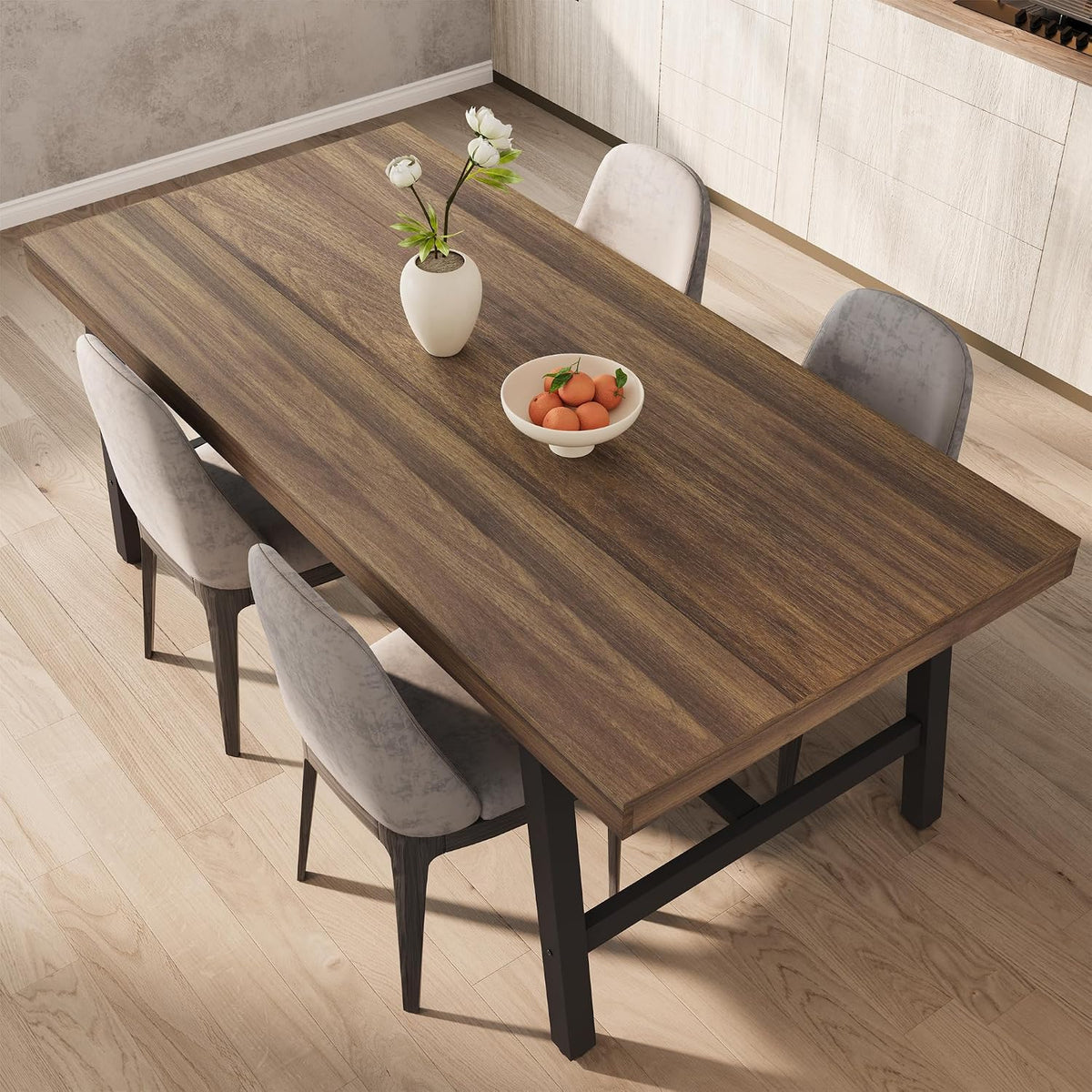 Overhead angled view of the brown laminate dining table with four chairs and a decorative bowl in a contemporary kitchen