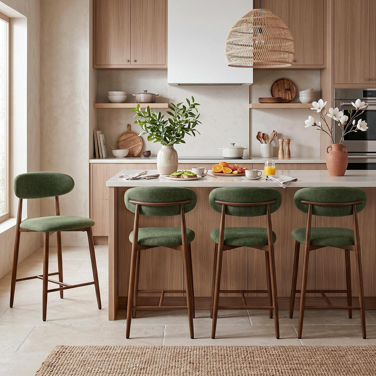 Kitchen counter with four green upholstered counter stools showing curved back pads and brown legs.