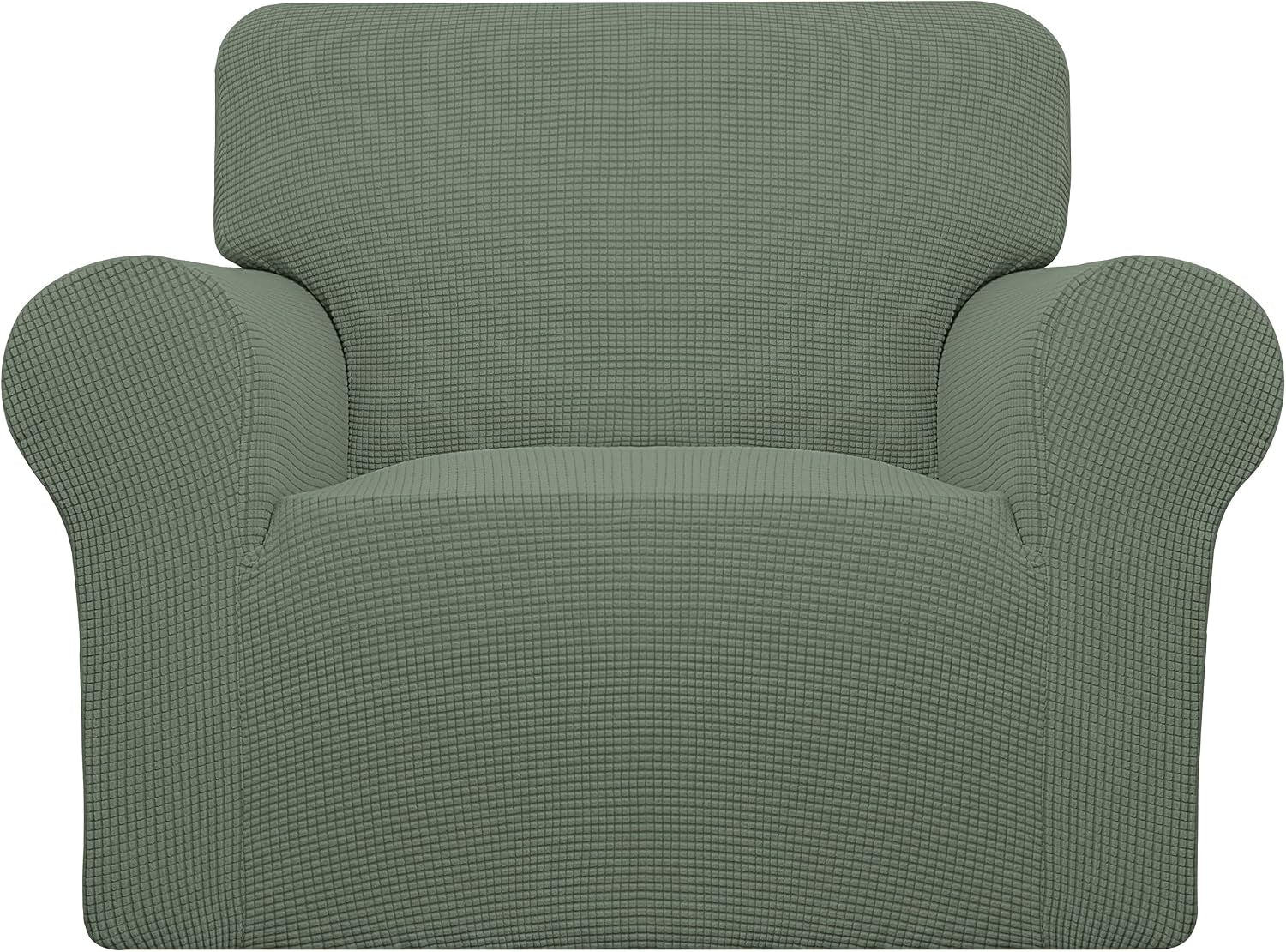 Close-up front view of a sage-green armchair cover highlighting the grid-like stretch texture and curved arms.