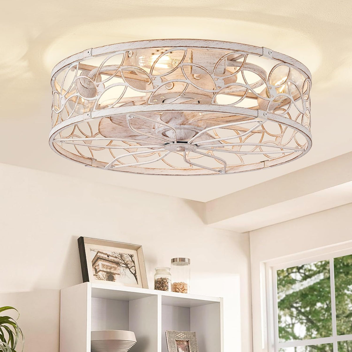 Flush-mount ceiling fan with decorative whitewashed metal cage and exposed bulbs above a shelving unit.