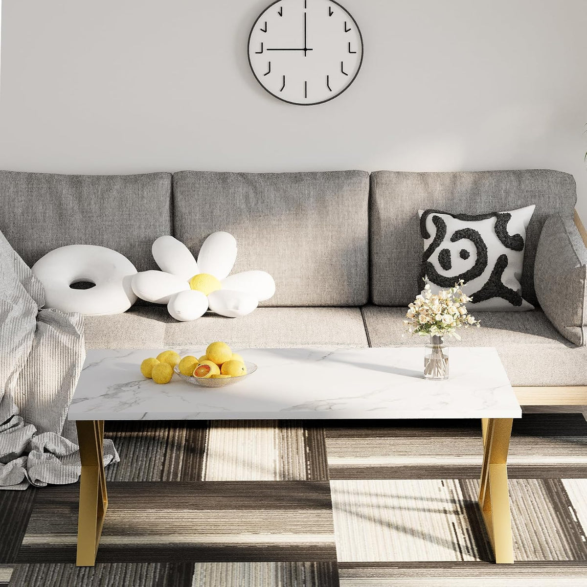 Rectangular faux-marble top coffee table with gold X-legs centered on a striped rug in front of a gray sofa.