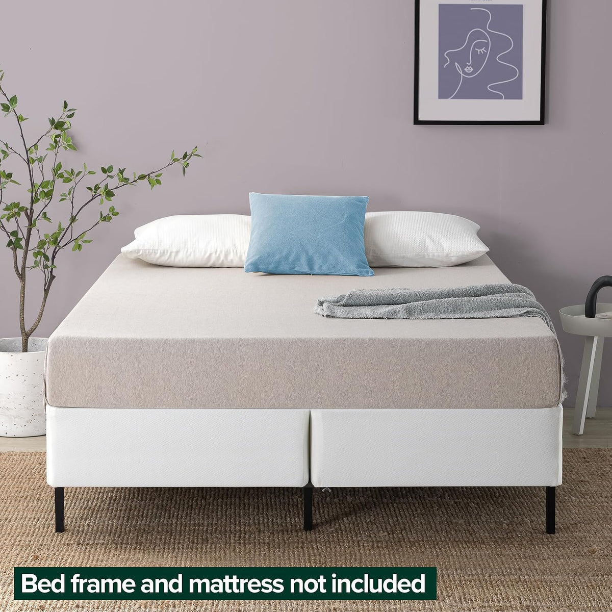 Staged bedroom showing a mattress over two white folding foundations on a metal frame