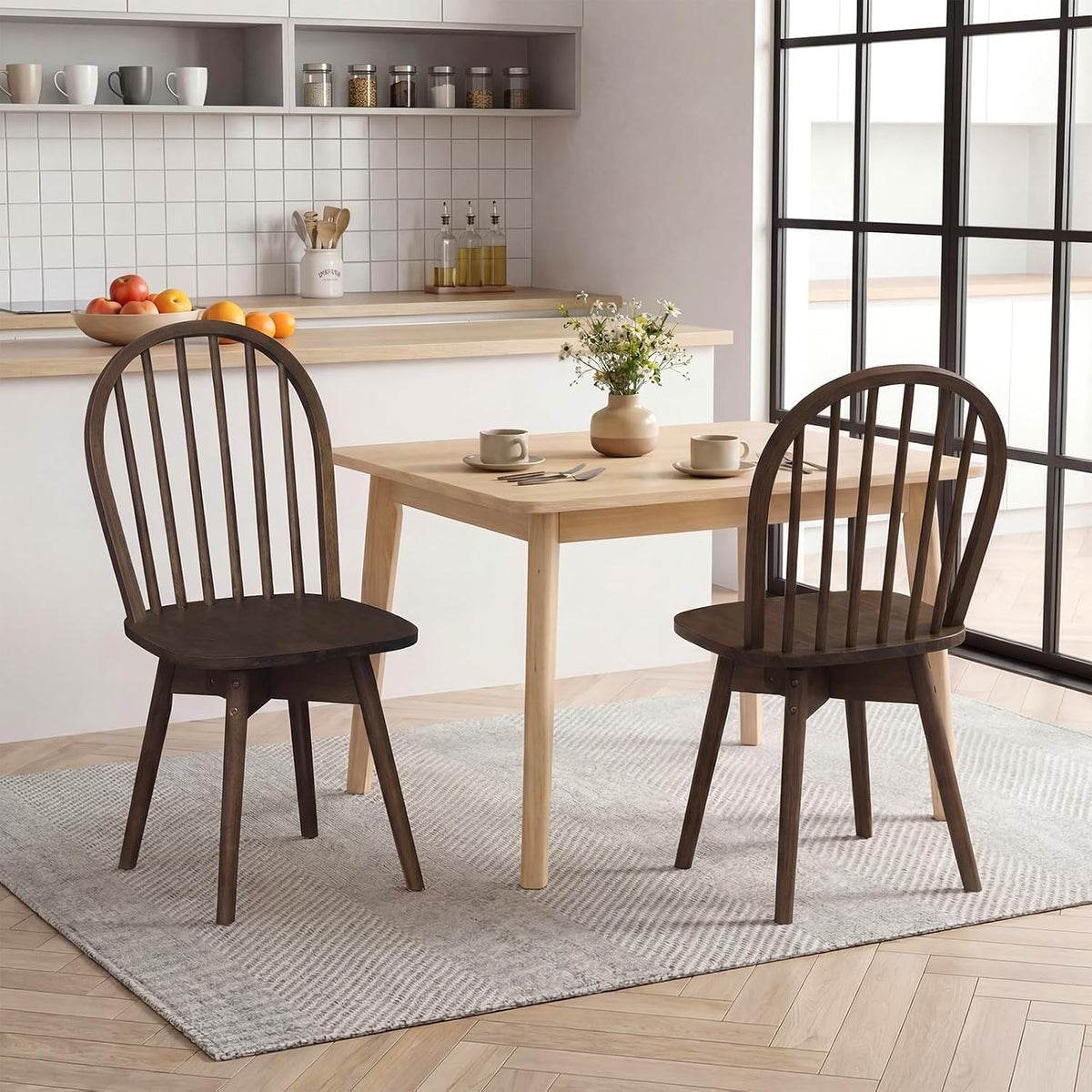 Two walnut Windsor chairs at a light wood dining table in a minimalist kitchen setting
