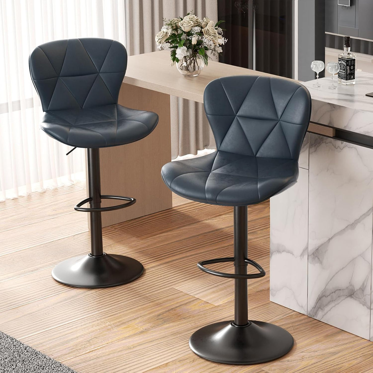 Two dark blue swivel stools shown from the front beside a light wood counter and a vase of flowers.