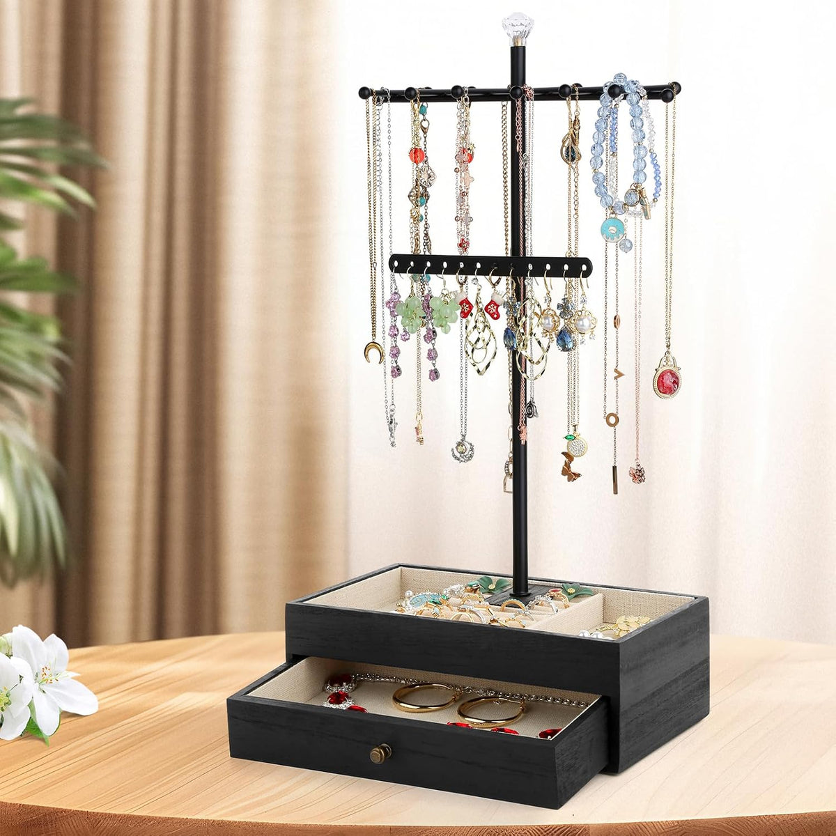 Black three-tier necklace tree shown on a vanity with linen-lined top compartments and hanging jewelry
