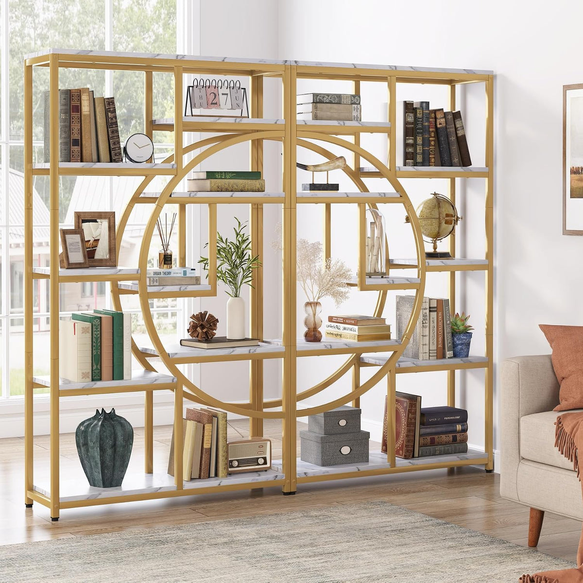 Two gold etageres paired to form a circular display, staged with books and decor in a living room