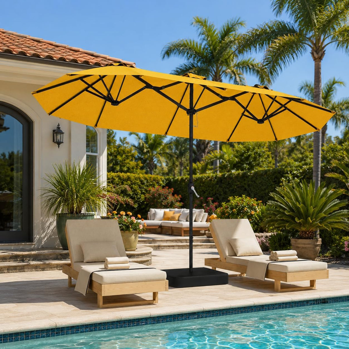 Yellow double-sided rectangular umbrella over a black base shading two lounge chairs beside a pool.