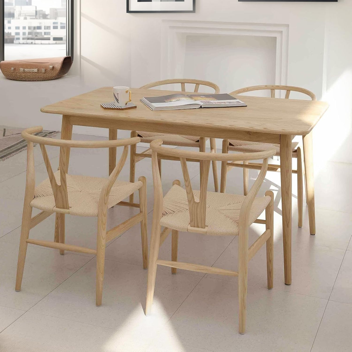Four natural ash dining chairs around a light wood dining table in a sunlit dining room setting