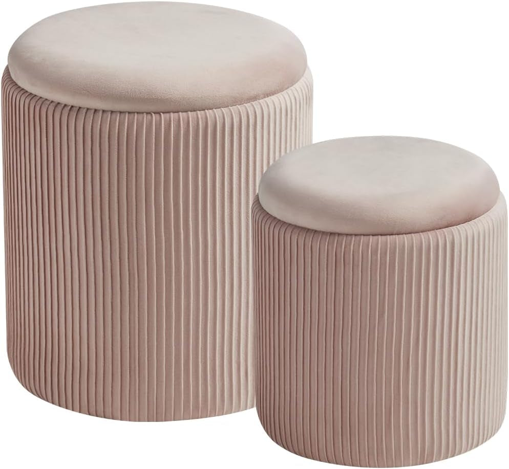 Two blush pink velvet round storage ottomans on white background, front view.
