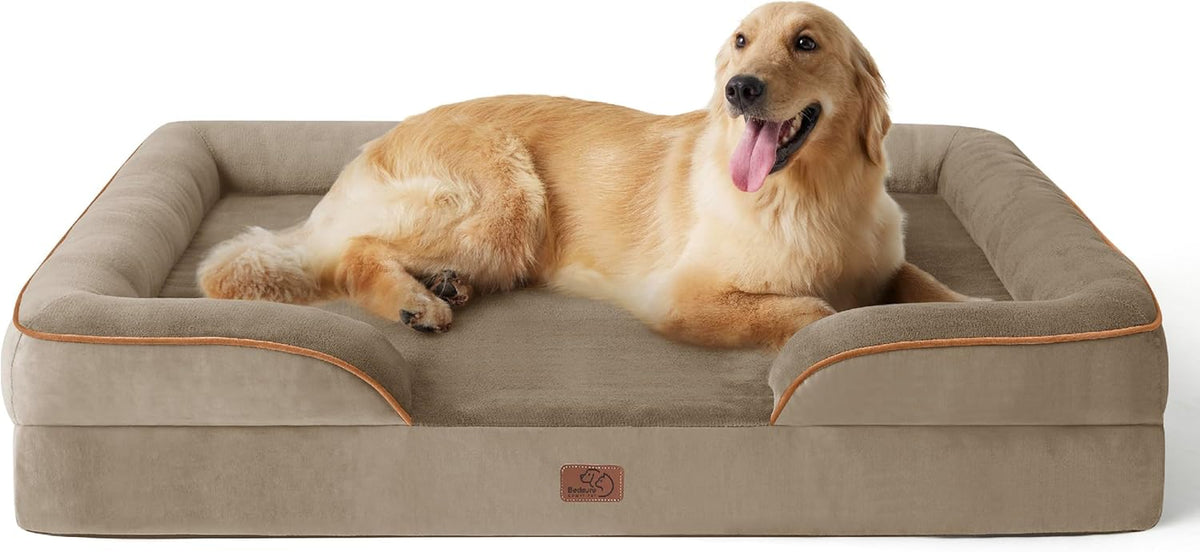 Golden retriever lying comfortably on a taupe/beige bolstered dog bed, angled front view.