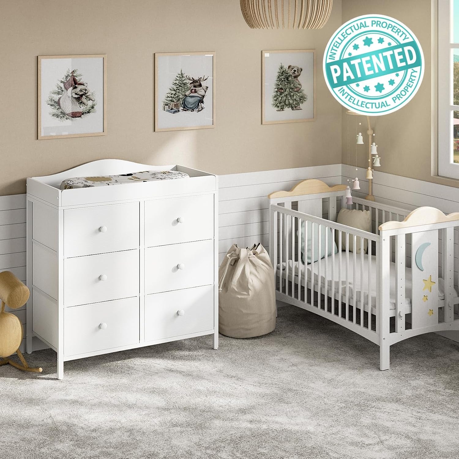 Staged nursery showing the white changing dresser beside a wooden crib and wall art above.