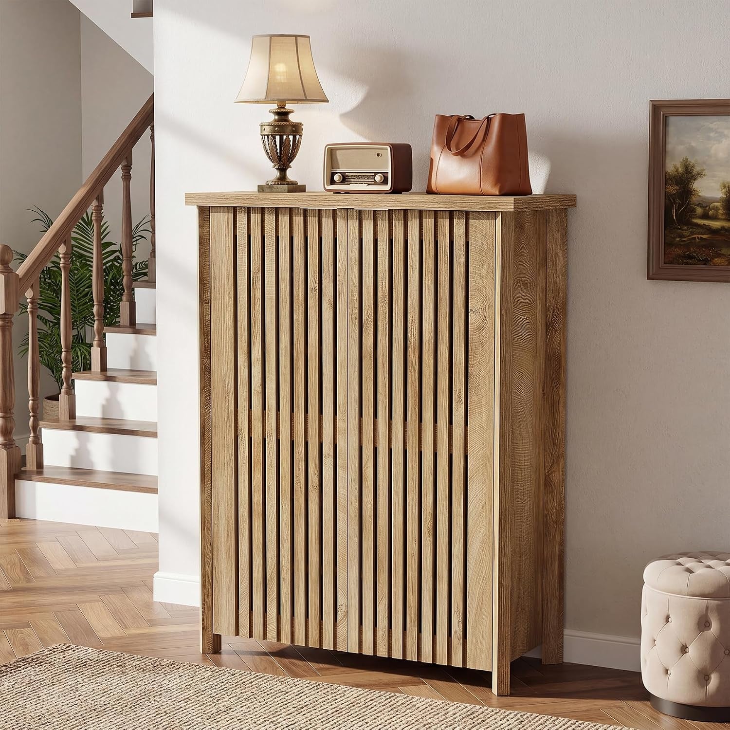 Light oak farmhouse shoe cabinet with vertical louvered doors angled front view by a staircase