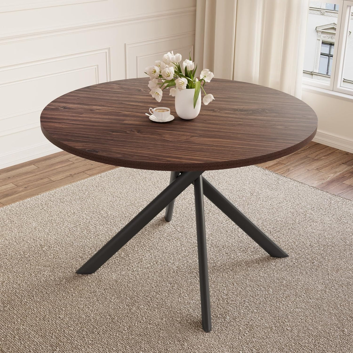 Round dark-walnut tabletop with black crossed metal legs on a neutral rug.