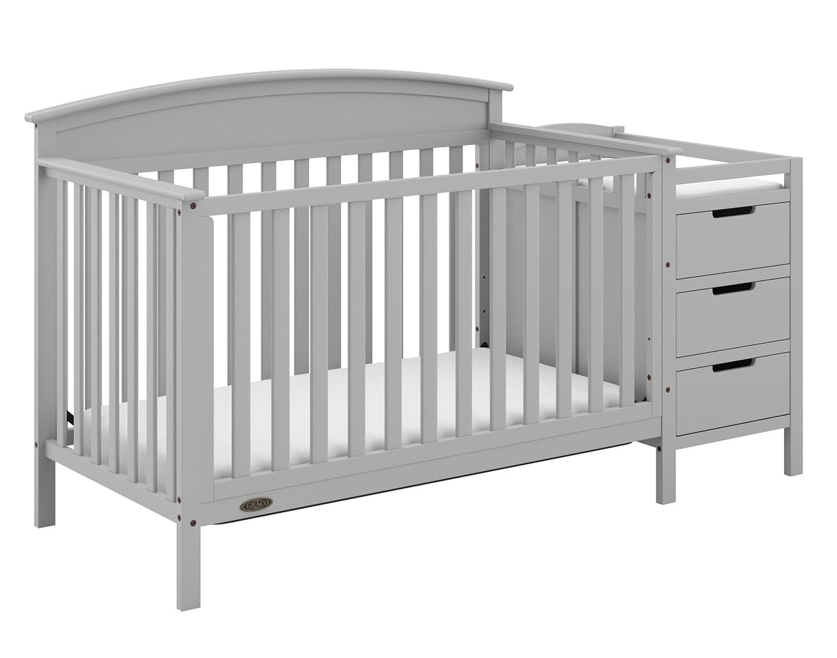 Gray convertible crib with attached three-drawer changing table shown at a slight angle