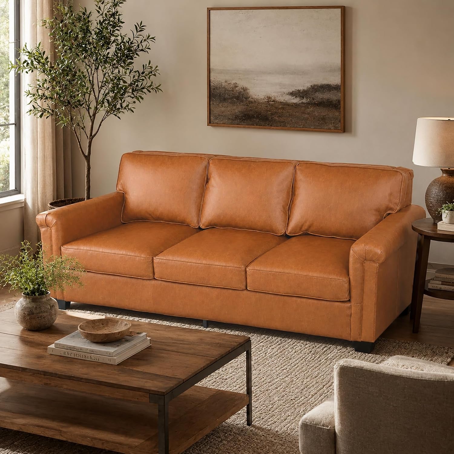 Front view of a warm tan/caramel three-seat leather sofa with rolled arms.