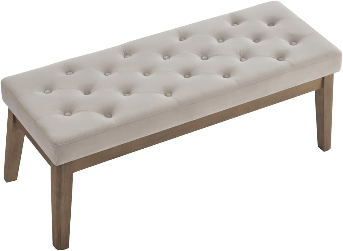 Three-quarter view of tufted bench showing full top, wood apron, and four angled legs on white