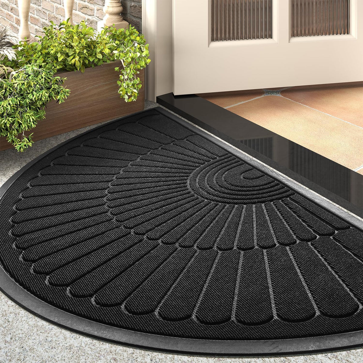 Black semicircular mat showing raised ribbed pattern and rubber border at a doorway