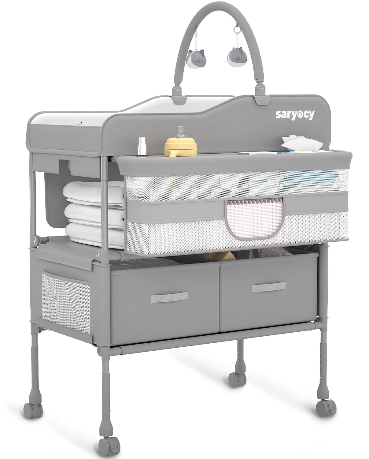 Gray folding baby changing table on wheels with mesh side basket, two fabric drawers and hanging toy arch.