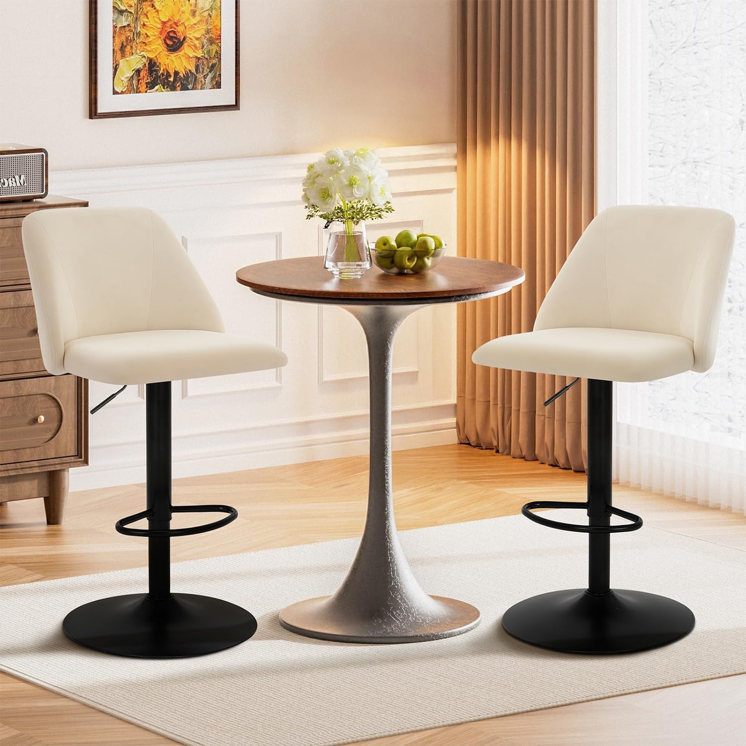 Two cream fabric swivel bar stools flanking a small round wood table in a bright sitting area