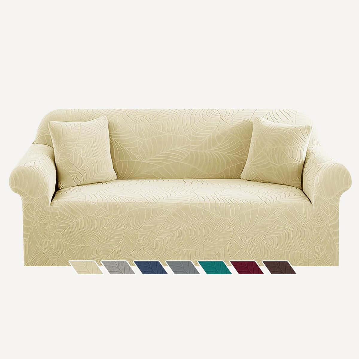 Beige leaf-patterned sofa cover fitted on a couch with two matching throw pillows