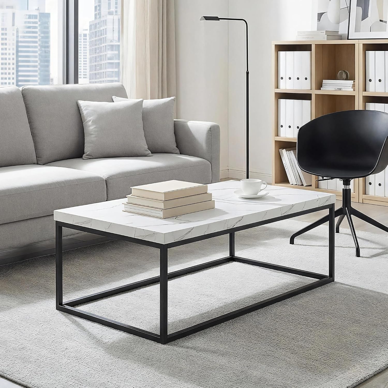 Rectangular marble-laminated coffee table in a modern living room with sofa and black accent chair