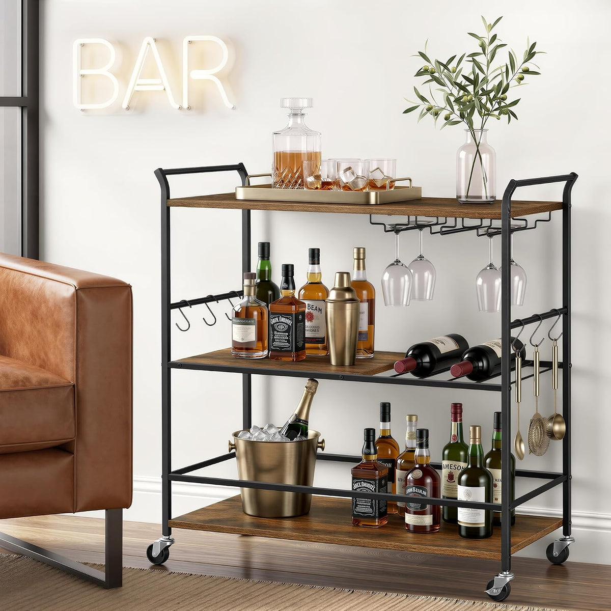 Three-tier bar cart with bottles and stemware on shelves, front view showing integrated wine racks and side hooks