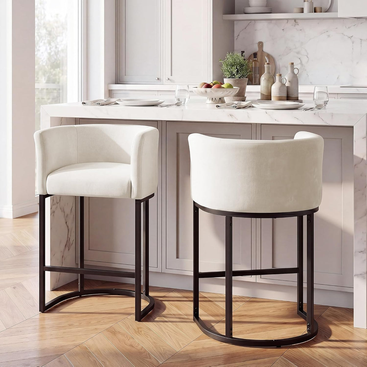 Two off-white bar stools placed at a marble island showing front and rear views and dark metal bases