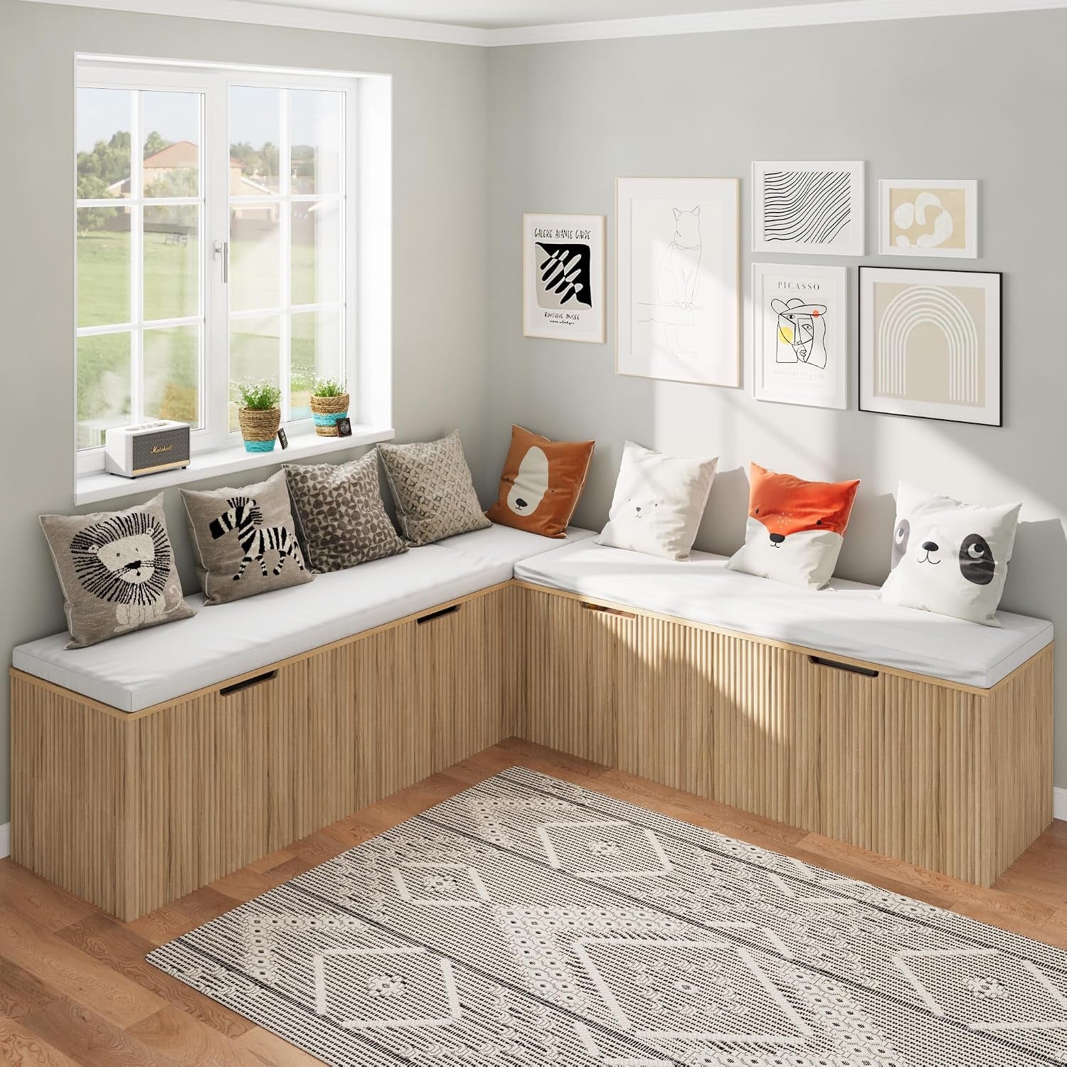 Light wood slatted L-shaped bench with white cushions and animal-themed throw pillows under a gallery wall