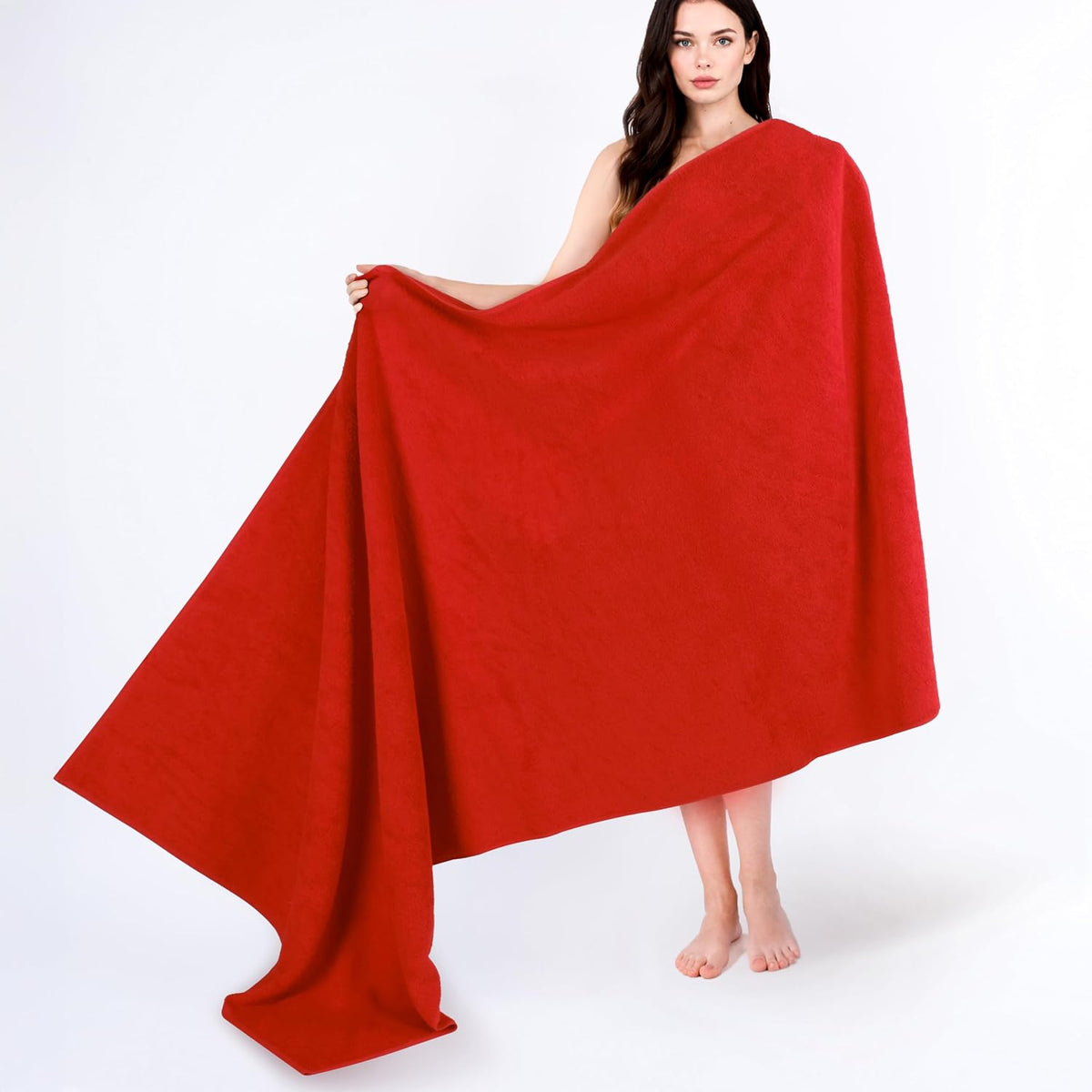 Model holding a large red towel open, showing full drop and drape against a white background.