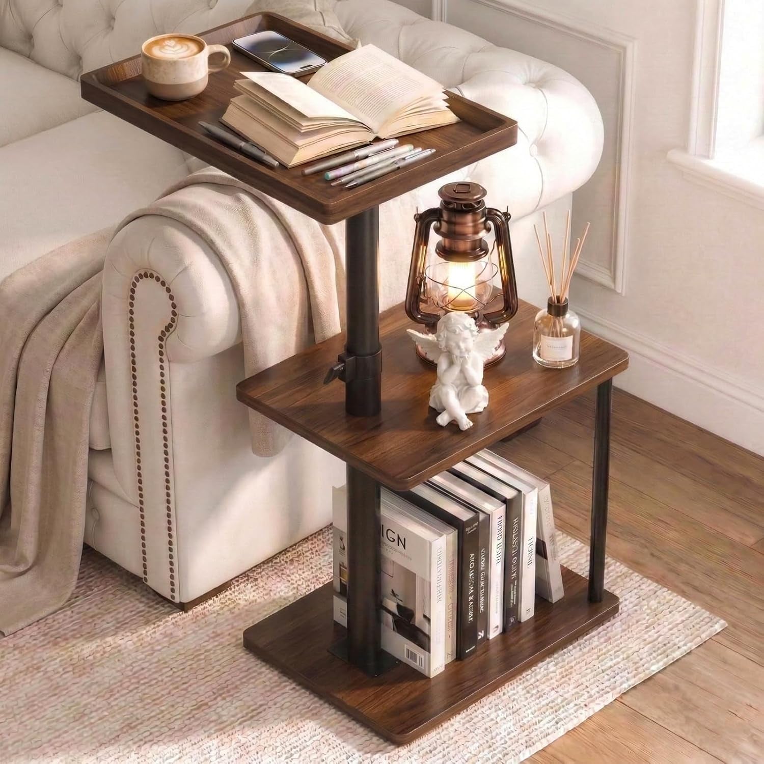Dark wood three-tier C-side table next to a tufted sofa holding a lamp, book and figurine.