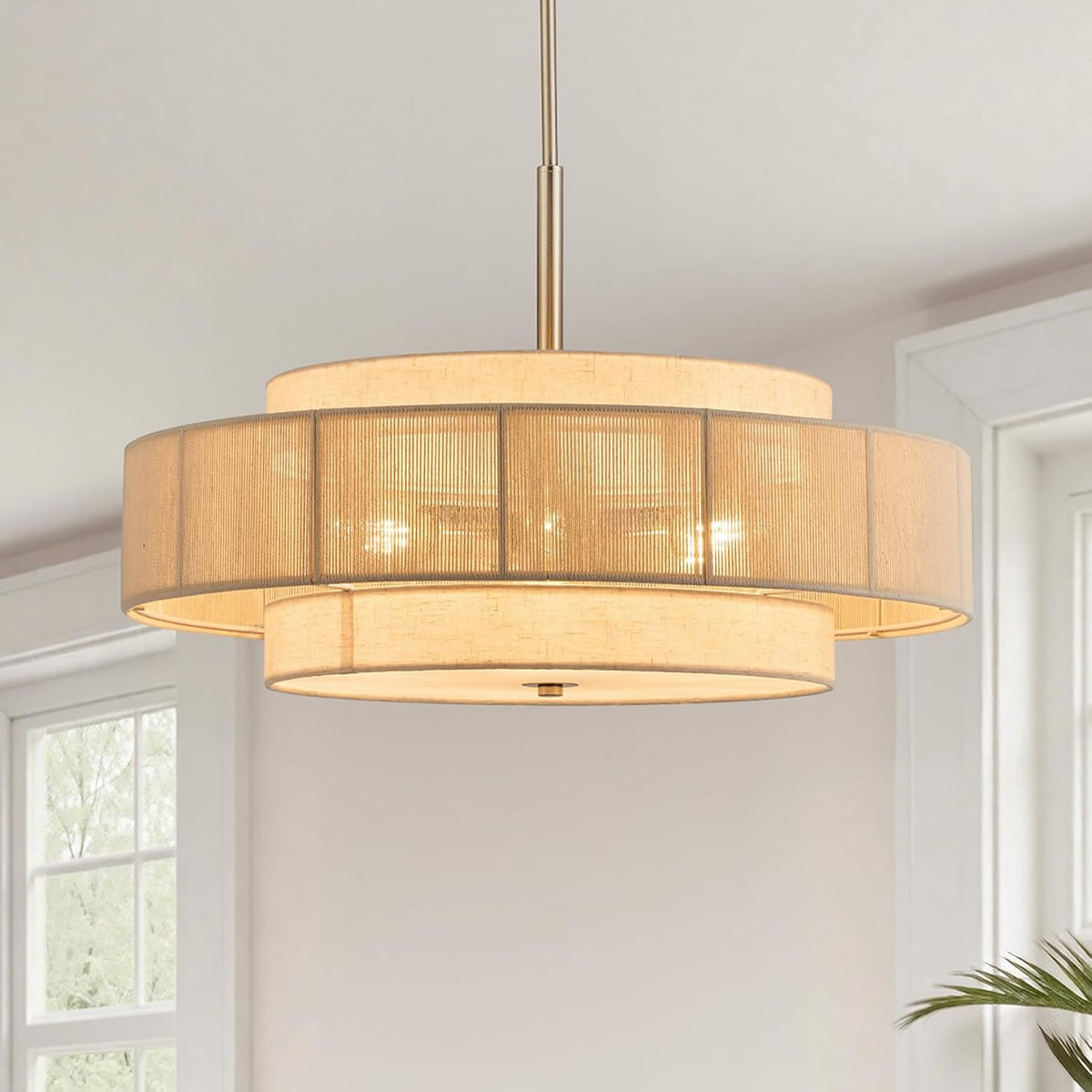 Close crop showing the chandelier's mesh outer drum revealing glowing bulbs behind the fabric shade.