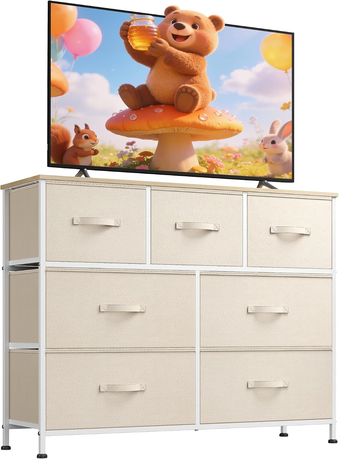 Cream-colored fabric-drawer dresser with light wood top holding a TV showing a cartoon bear scene