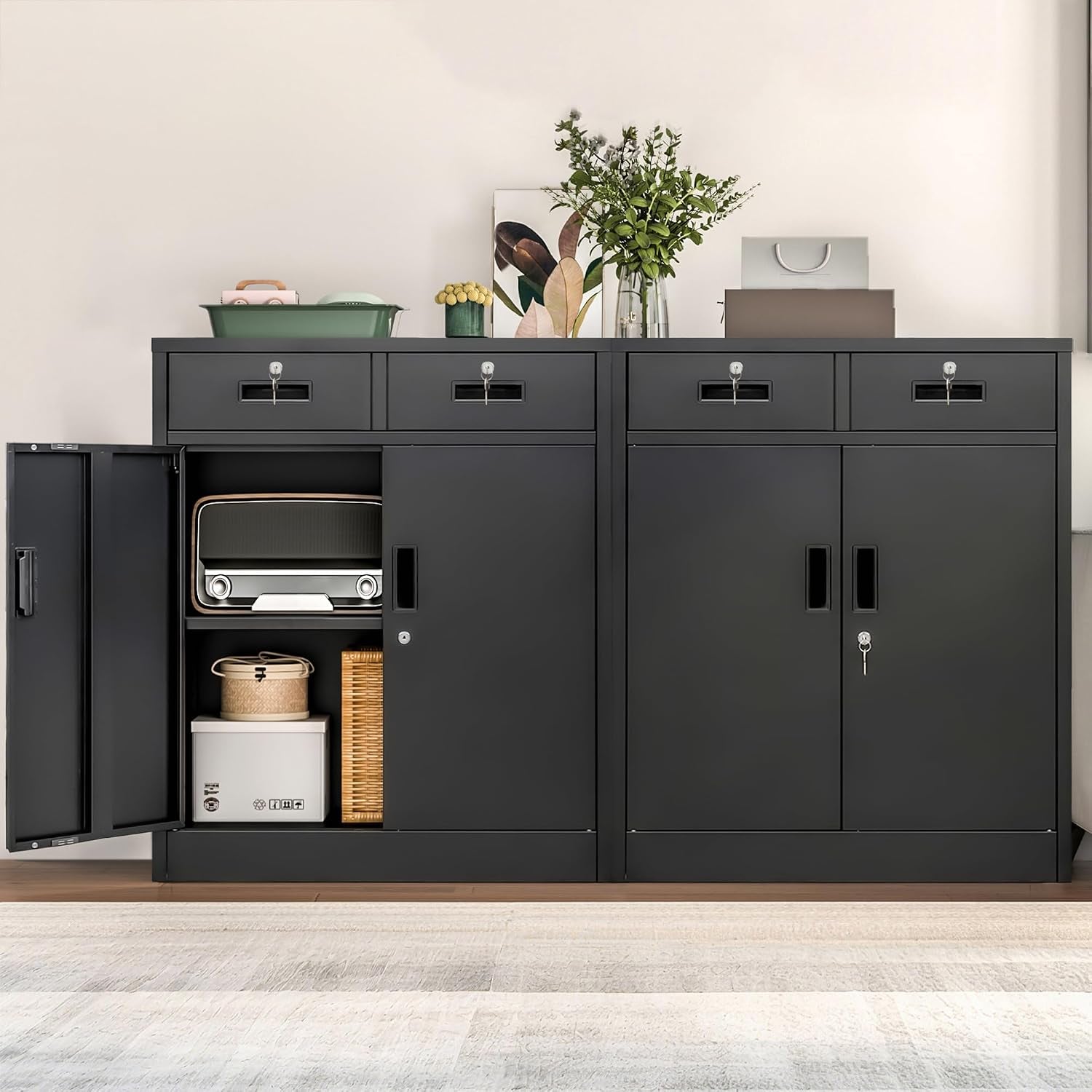 Two black metal storage cabinets placed side by side, left door open showing stacked household items and top drawers keyed