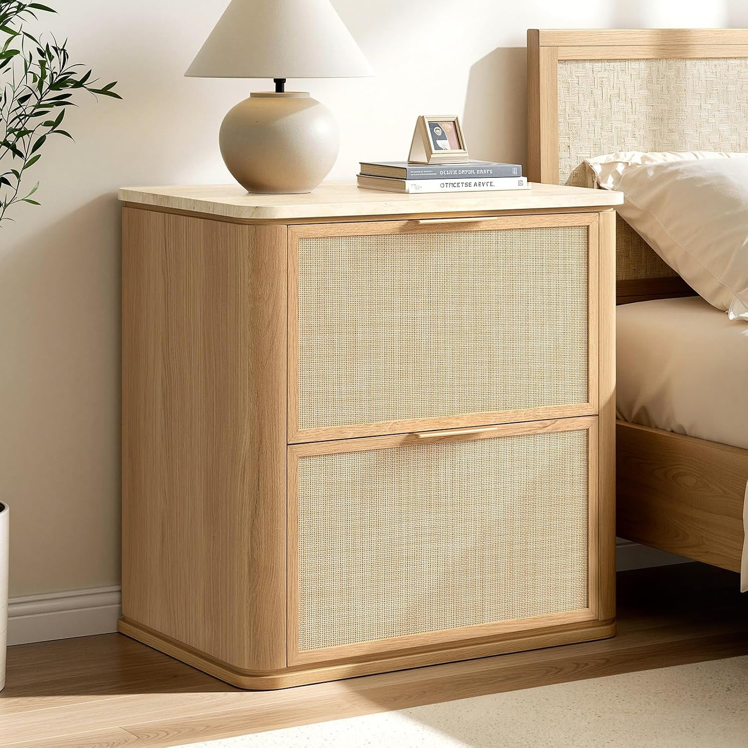 Light oak two-drawer nightstand with woven rattan drawer fronts and lamp on top.