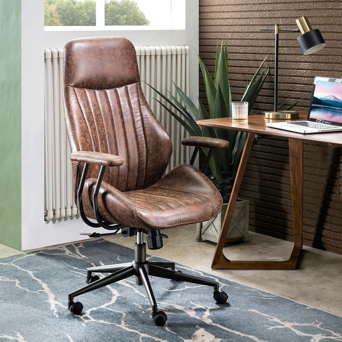 Distressed brown high-back chair angled left beside a wooden desk, radiator and tall plant in the background.