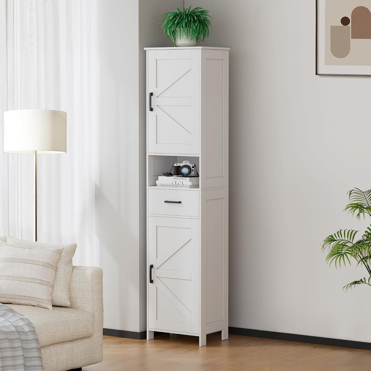 White tall storage cabinet in a living room corner, angled front view showing drawer, door panels, and cubby