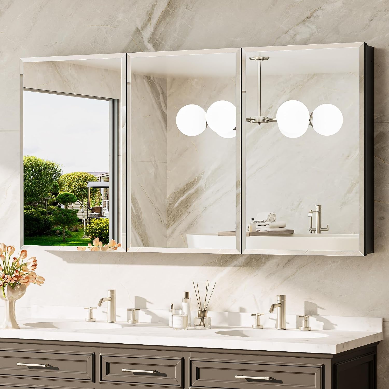 Three mirrored cabinet doors installed side-by-side above a double sink vanity with decor on the counter.